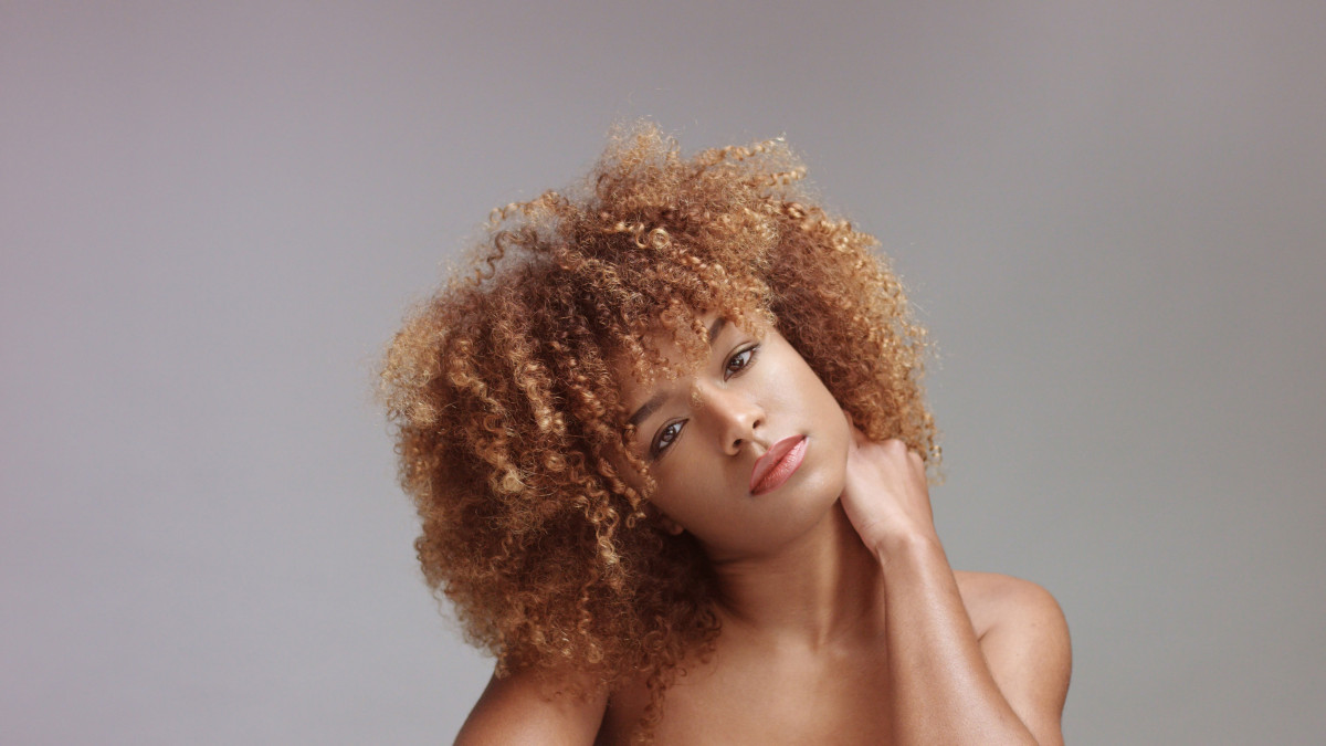 Une jolie jeune femme avec des cheveux crépus. 